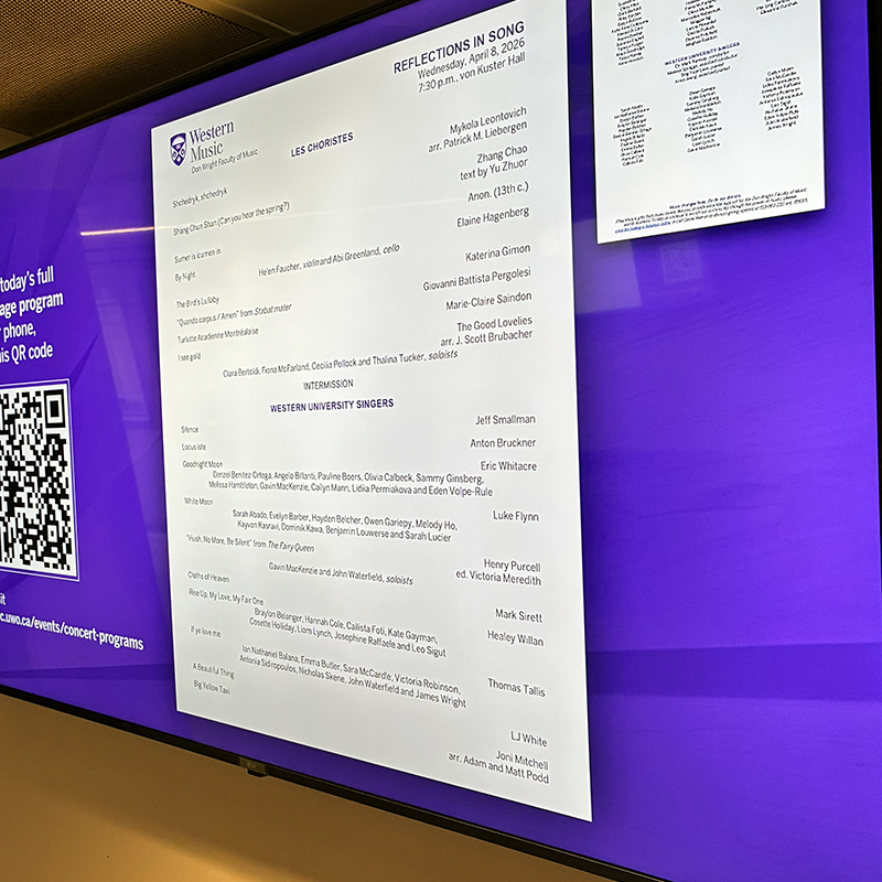 A digital screen outside von Kuster Hall displaying a concert program