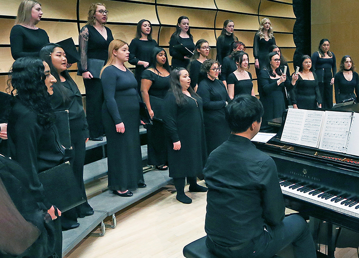 Choirs performing on stage in von Kuster Hall