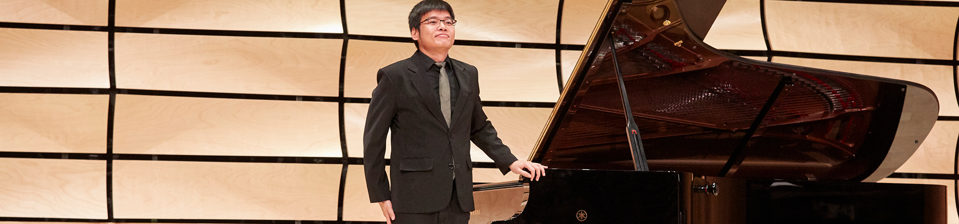 Piano student smiling on stage after a performance