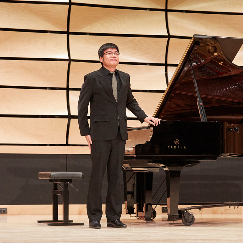 Piano student smiling on stage after a performance