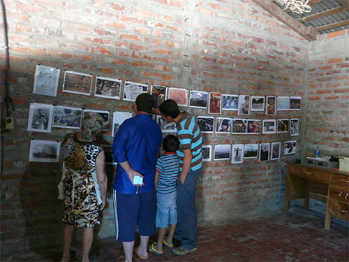 Former refugees examine the team's photo exhibit