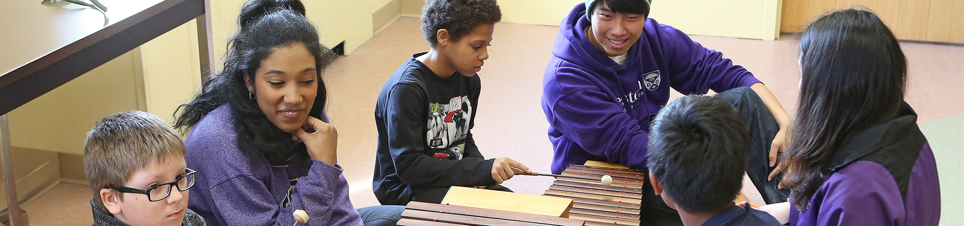 Students teaching children in the Music Education room