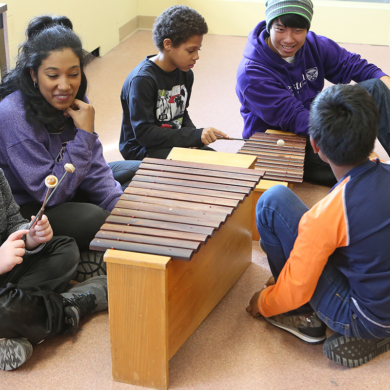 Students teaching children in the Music Education room