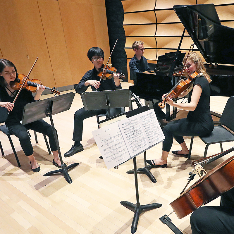 Piano Quintet chamber group performs on stage in von Kuster Hall