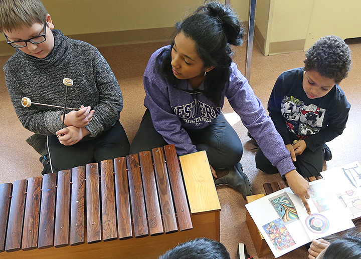 Music education student teaching a group of children