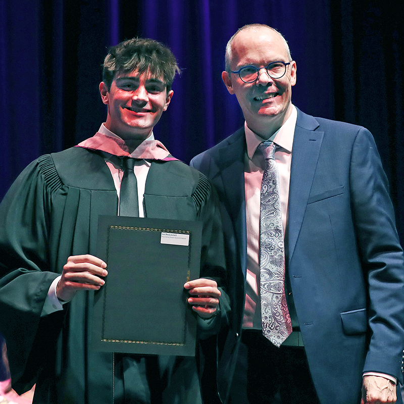 Award recipient receiving an award from a music faculty member