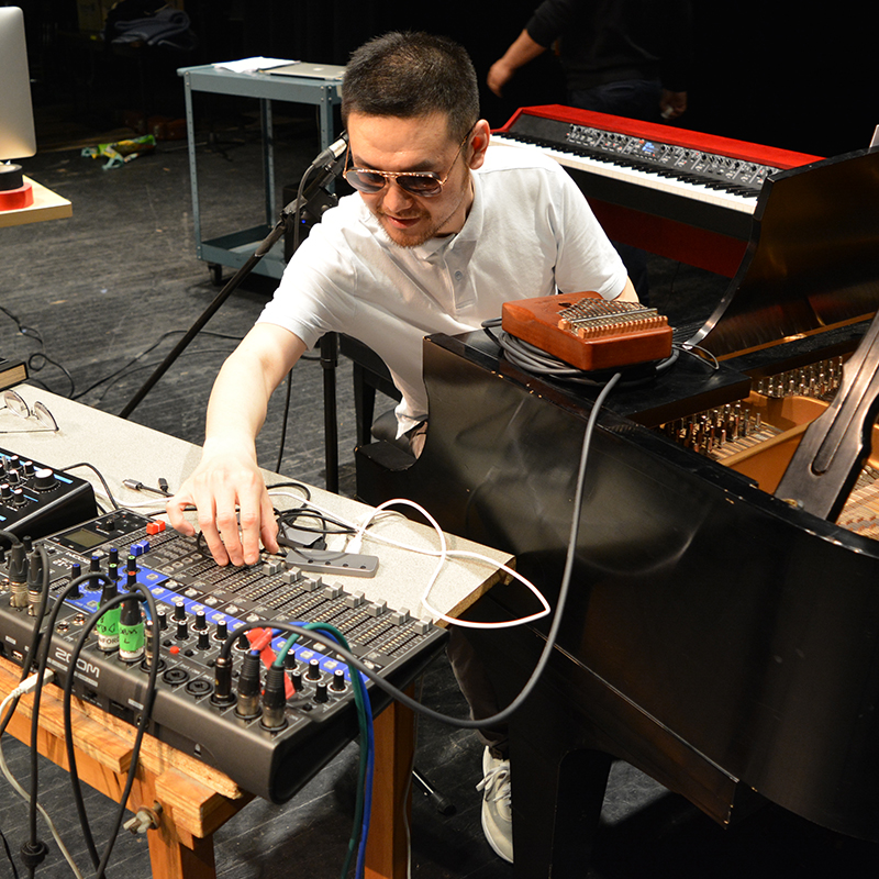 Student composer on stage in rehearsal
