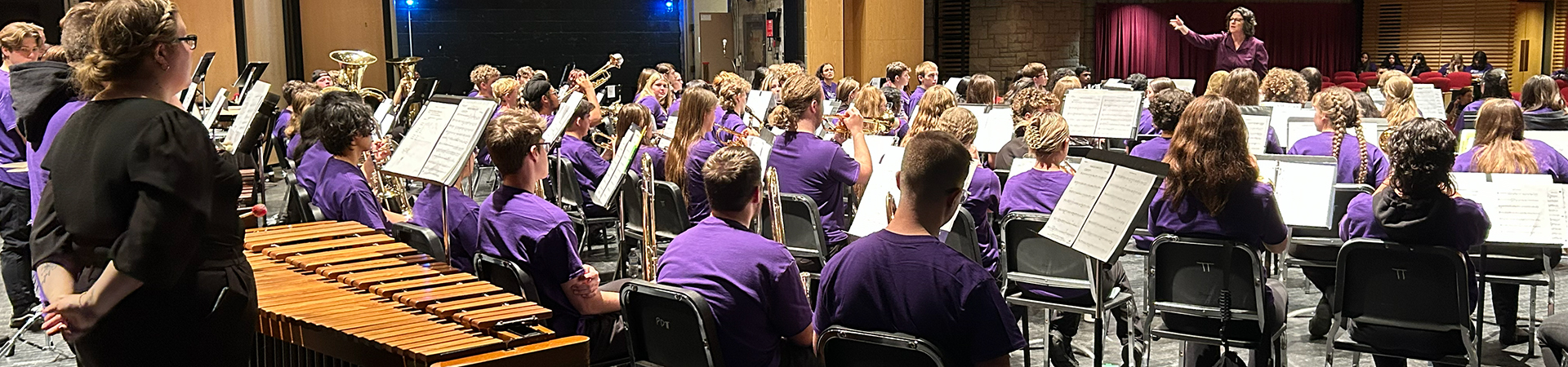 A conductor leading a large wind band ensemble