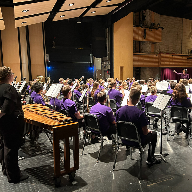 A conductor leading a large wind band