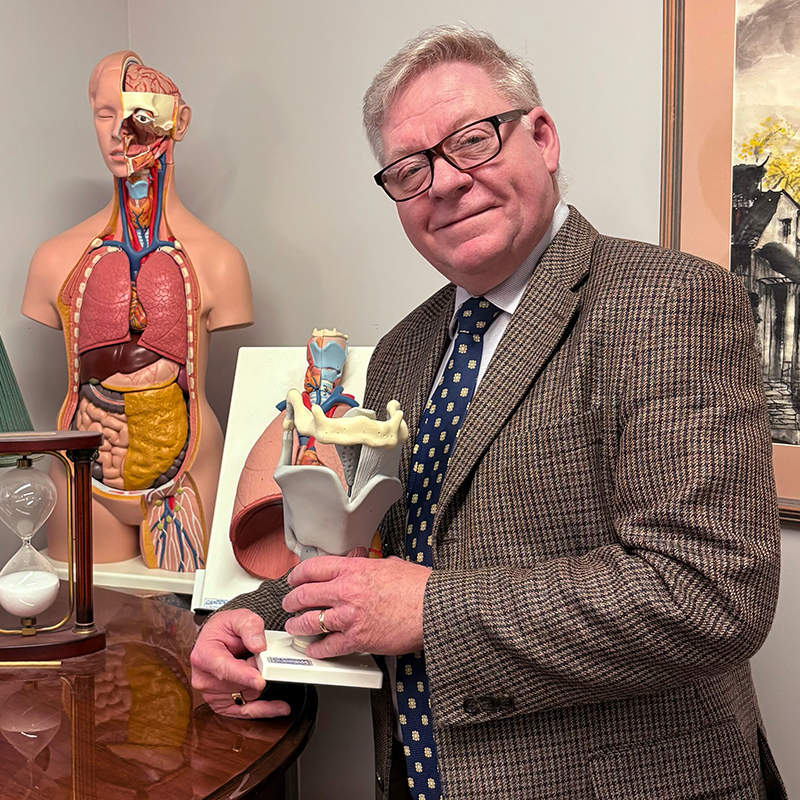 Voice faculty member with models of voice-related body parts