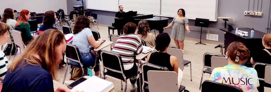 A singer performing in front of a group in a classroom